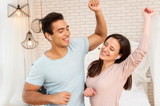 Tiro medio pareja sonriente bailando en el dormitorio