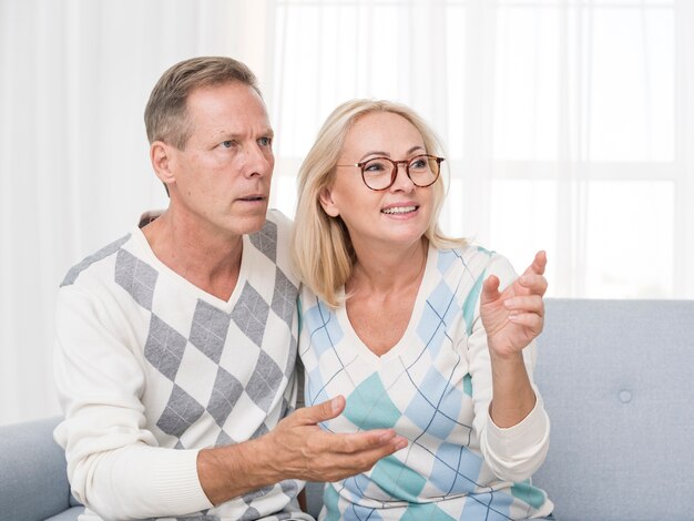 Tiro medio pareja sonriente en el sofá