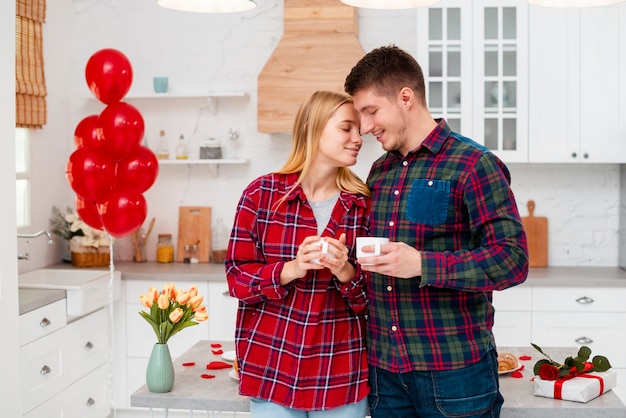 Foto gratuita tiro medio pareja con tazas de café en el interior