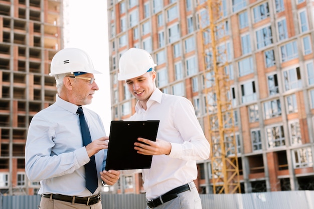 Tiro medio personas hablando sobre proyecto de construcción