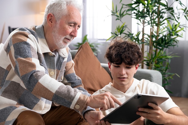 Foto gratuita tiro medio senior hombre y niño con tableta