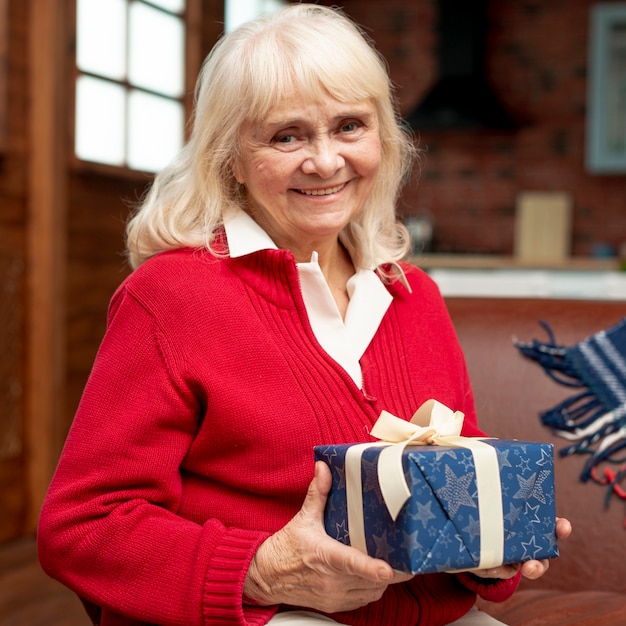 Tiro medio sonriente abuela con regalo