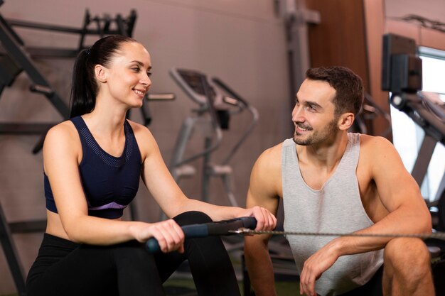 Foto gratuita tiro medio, sonriente, hombre y mujer, en, gimnasio