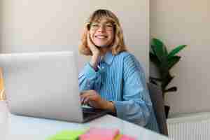 Foto gratuita tiro medio sonriente mujer que trabaja en la computadora portátil