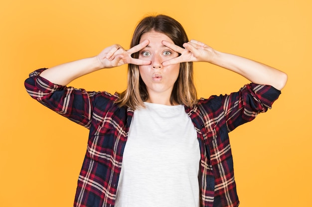 Tiro medio sorprendido niña haciendo signo de la paz