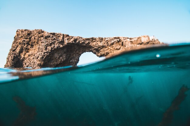 Tiro a nivel de la superficie del agua de rocas y arrecifes en el mar en un día soleado