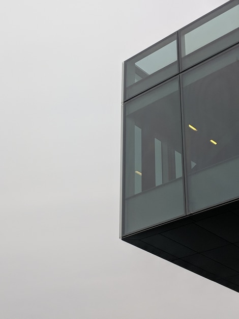 Tiro vertical de ángulo bajo de un edificio negro de gran altura con ventanas de vidrio