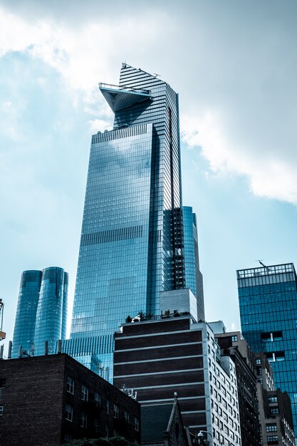 Tiro vertical de ángulo bajo de modernos edificios de negocios de vidrio tocando el cielo