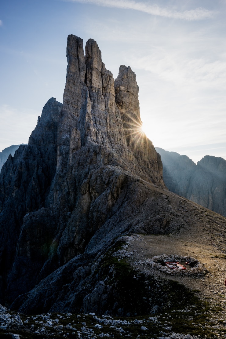 Foto gratuito tiro vertical de una chimenea en la montaña con un cielo azul en el fondo