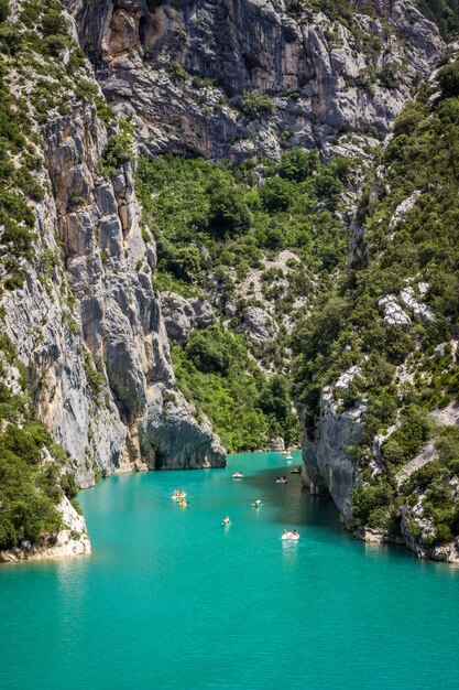 Tiro vertical del cuerpo de agua entre acantilados rocosos y montañas