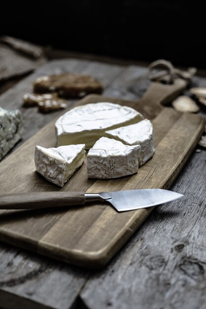 Tiro vertical de delicioso queso brie en una terraza de madera