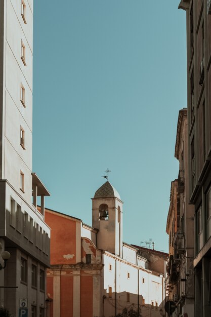 Tiro vertical de edificios en el campanario en la distancia y un cielo azul