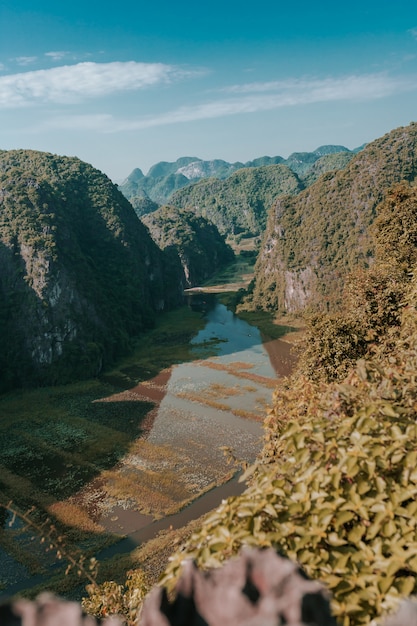 Foto gratuita tiro vertical de la hermosa cordillera y un lago bajo el cielo nublado