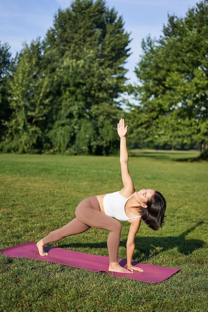 Mujer bonita haciendo ejercicios de yoga en el parque retrato de mujer en  ropa deportiva practicando yoga en la naturaleza