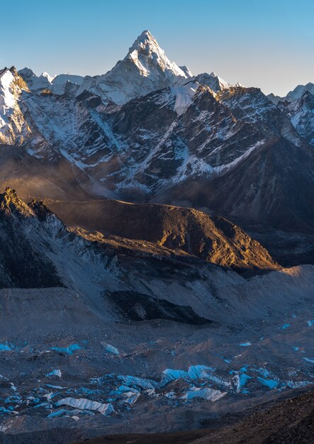 Tiro vertical de Khumbu y Ama Dablam con un cielo azul en el