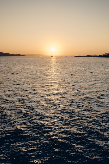 Tiro vertical del mar que refleja la luz del sol con un hermoso cielo