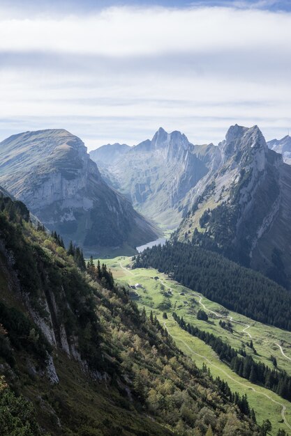 Tiro vertical de montañas boscosas bajo un cielo nublado durante el día