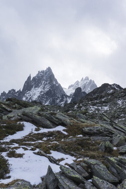 Tiro vertical de montañas nevadas con un cielo nublado