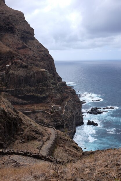 Tiro vertical de una roca a la orilla del mar bajo el cielo sombrío