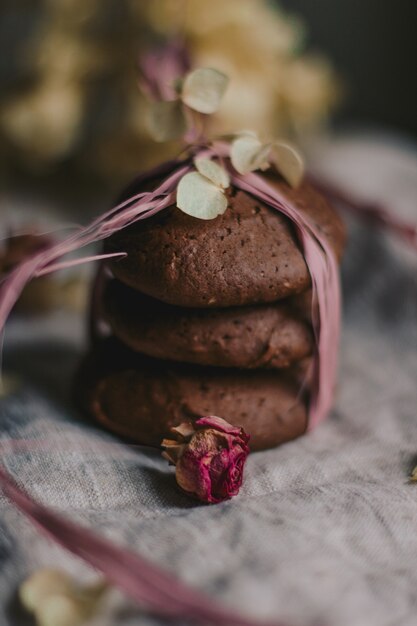 Tiro vertical selectivo del primer de las galletas de chocolate apiladas envueltas con un hilo rosado