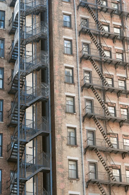 Tiro vertical de viejos edificios de apartamentos de piedra con escaleras de salida de incendios en los lados