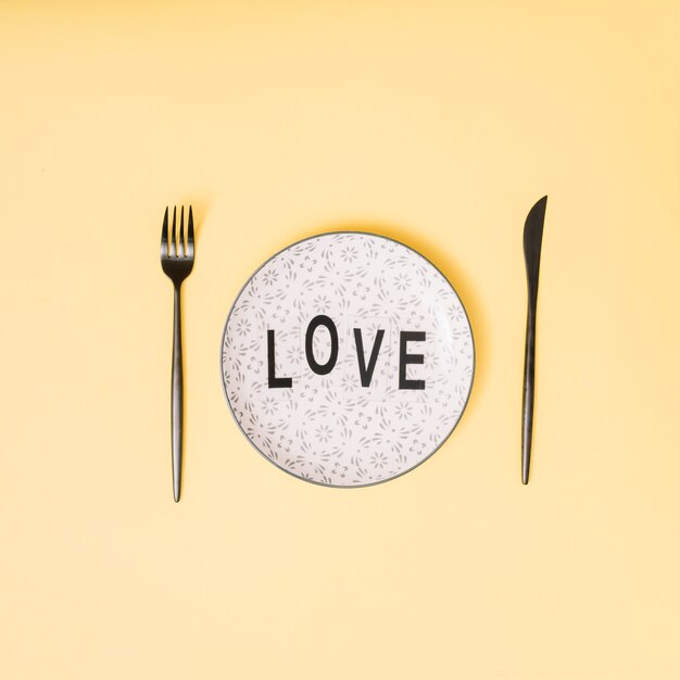 Título de amor en un plato hermoso entre los cubiertos.
