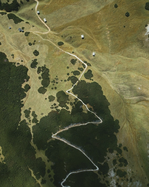 Foto gratuita título vertical en forma de ojo de águila de una carretera estrecha en la cima de la colina