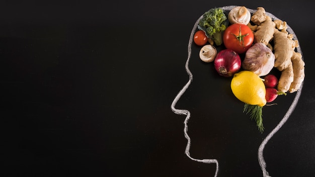 Foto gratuita tiza dibujado cabeza humana con alimentos saludables para el cerebro en la pizarra