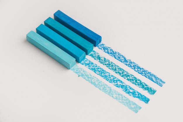 Foto gratuita tizas de crayón pastel de color azul sobre su propia línea de trazado