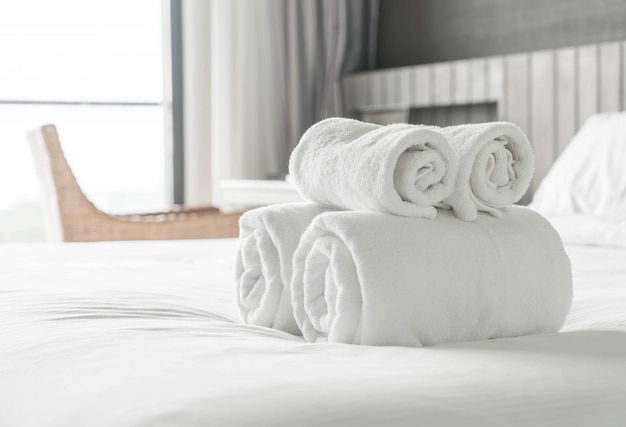 Toalla blanca en la decoración de la cama en el interior del dormitorio
