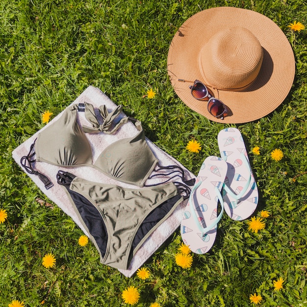 Toalla en el campo con bikini y otros accesorios de verano