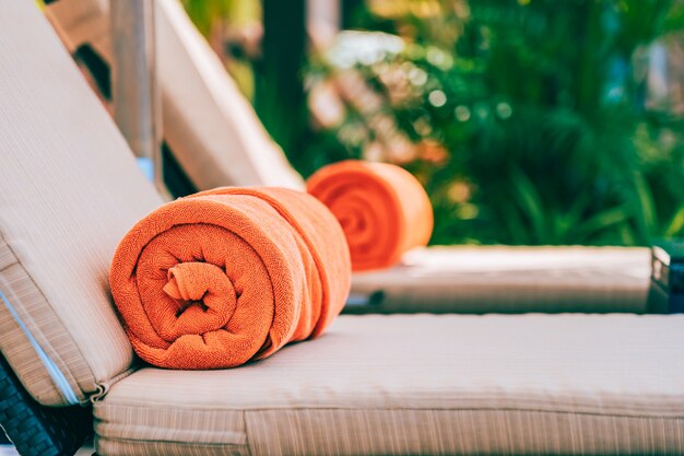 Toalla de piscina naranja en tumbona