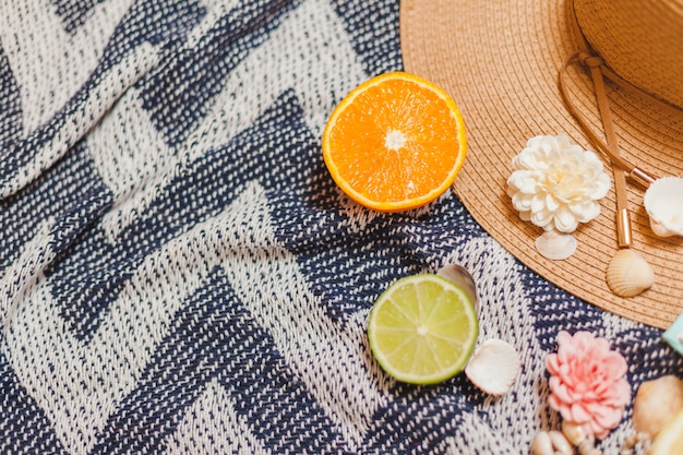 Foto gratuita toalla de playa con frutas y sombrero