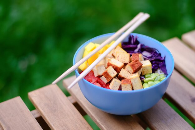 Tofu vegetariano poke bowl sobre mesa de madera