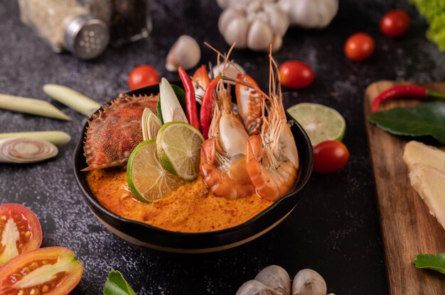 Tom yum con camarones y cangrejo con lima, chile, tomate, ajo, limoncillo y hojas de lima kaffir.