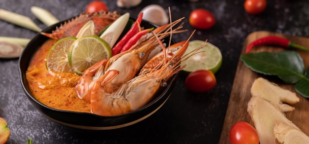 Tom yum con camarones y cangrejo con lima, chile, tomate, ajo, limoncillo y hojas de lima kaffir.