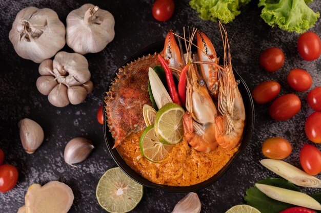 Tom yum con camarones y cangrejo con lima, chile, tomate, ajo, limoncillo y hojas de lima kaffir.