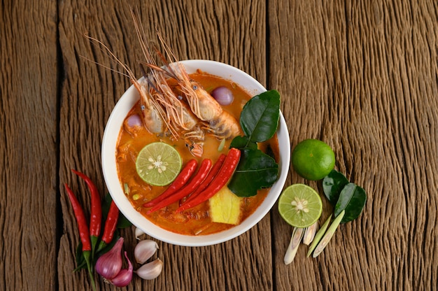 Tom Yum Kung Thai sopa picante de camarones con hierba de limón, limón, galanga y chile en mesa de madera, comida de Tailandia