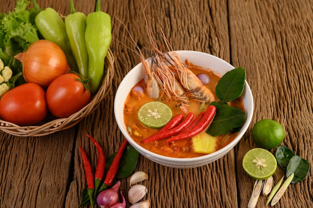 Tom Yum Kung Thai sopa picante de camarones con hierba de limón, limón, galanga y chile en mesa de madera, comida de Tailandia