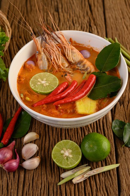 Tom Yum Kung Thai sopa picante de camarones con hierba de limón, limón, galanga y chile en mesa de madera, comida de Tailandia