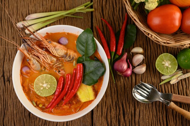 Tom Yum Kung Thai sopa picante de camarones con hierba de limón, limón, galanga y chile en mesa de madera, comida de Tailandia