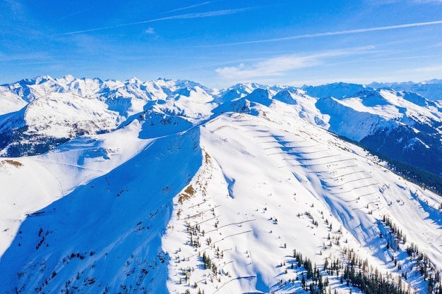 Toma aérea de altas montañas nevadas en Austria en un día soleado