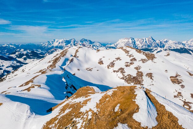Toma aérea de altas montañas nevadas en Austria en un día soleado