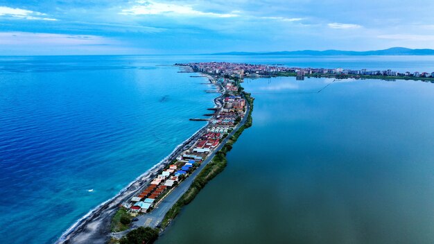 Toma aérea de casas en la costa estrecha en medio del mar