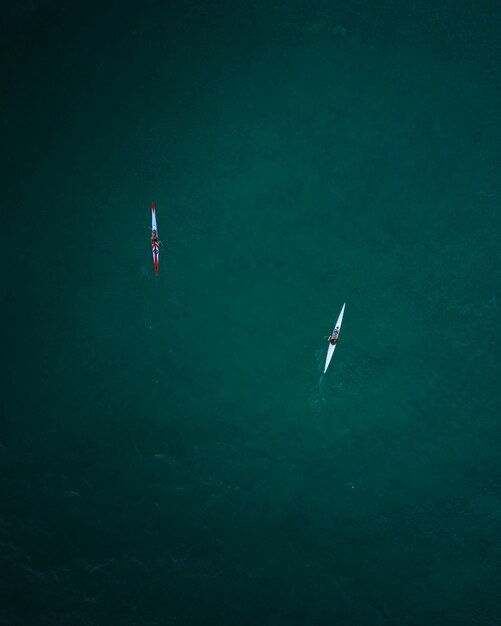 Toma aérea de dos kayaks navegando en mar abierto