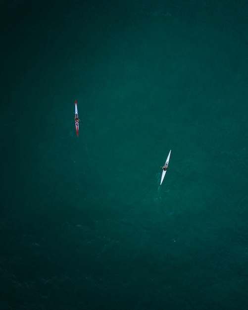 Toma aérea de dos kayaks navegando en mar abierto