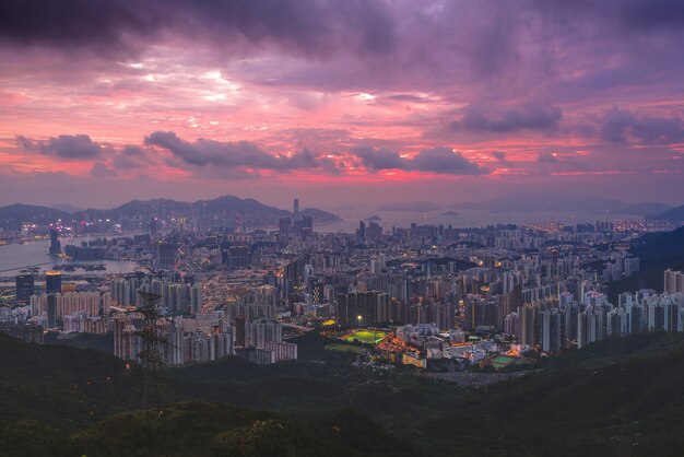 Toma aérea de edificios de la ciudad y carreteras con luces al atardecer