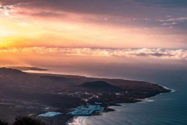 Toma aérea de una hermosa costa costera de la ciudad con nubes increíbles y luz solar a la izquierda