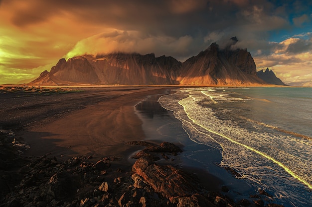 Toma aérea hermosa de una orilla del mar con colinas en el fondo al atardecer