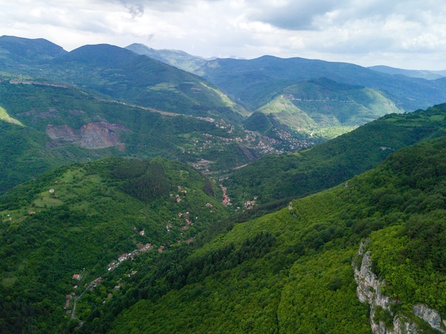 Toma aérea de las hermosas montañas y valles cubiertos de césped y árboles